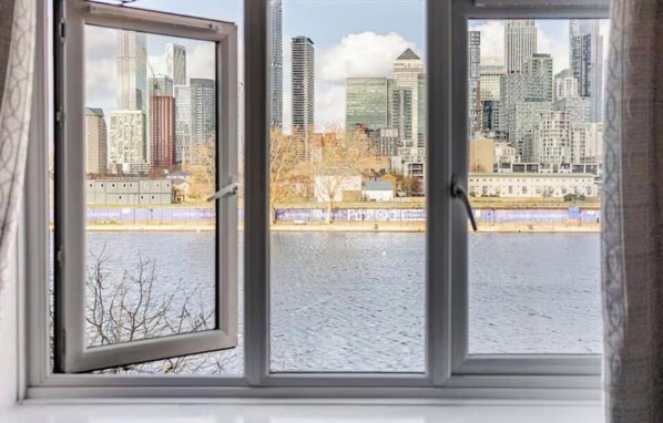 A view through a window with a cityscape and a body of water.
