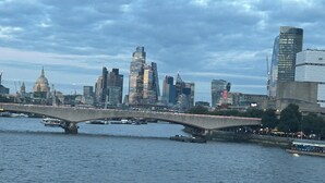 A city skyline with modern buildings, a historic dome, and a bridge over a river. - Beautiful view Apt
Near Canary Wharf (London)