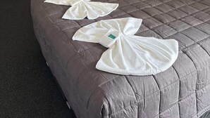 Een hotelkamer met een bed, een bureau, een stoel, een tafel en een airconditioning.