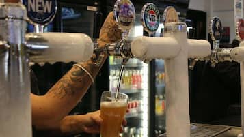 Een barman giet bier van de tap in een glas.