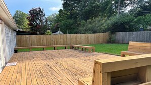 A wooden deck with benches and a picnic table. - Spacious 4-bedroom house in charming Memphis with AC, WiFi (Memphis)