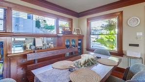 A dining area with a wooden table, two chairs, and a decorative centerpiece.