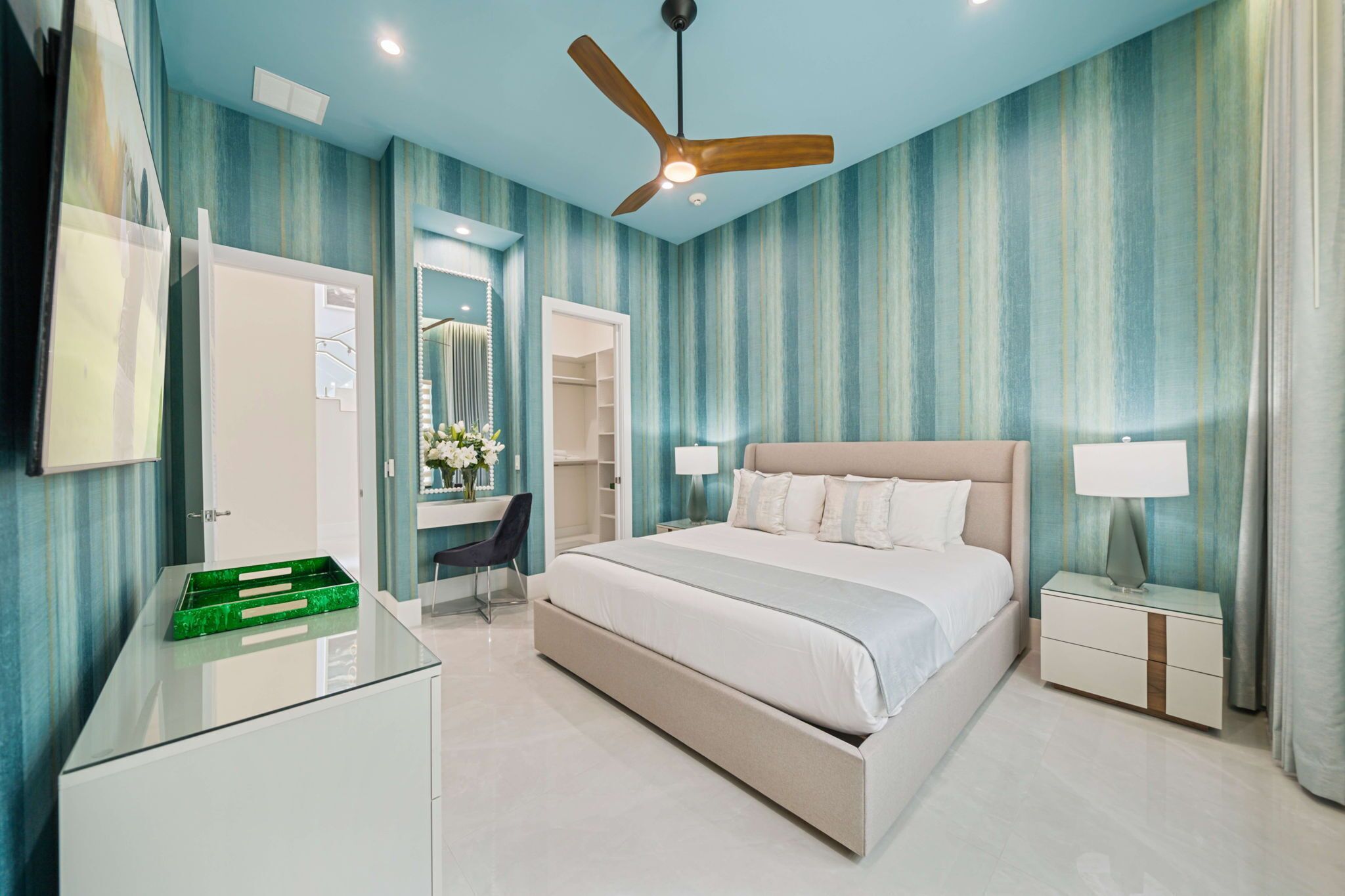 A bedroom with a bed, nightstand, dresser, and a ceiling fan.