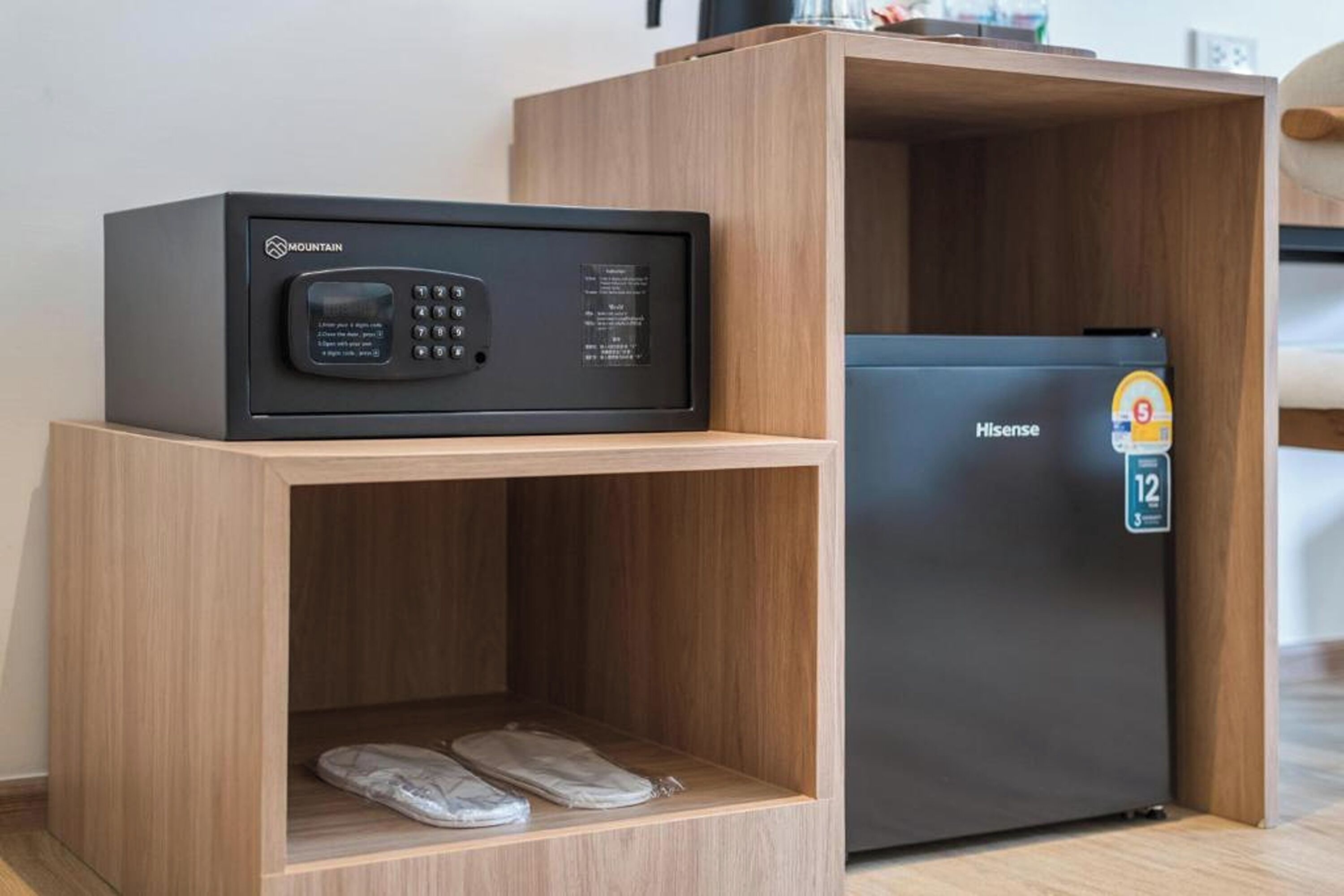Ein kompakter Wohnbereich mit Mikrowelle, Kühlschrank und einem Holzkabinett für Schuhe.