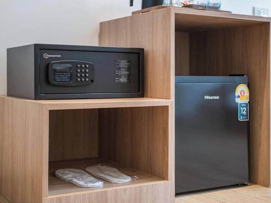 Ein kompakter Wohnbereich mit Mikrowelle, Kühlschrank und einem Holzkabinett für Schuhe.
