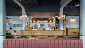 A restaurant with a counter, seating area, and visible kitchen. - Upstairs at Ton Ton (Bangkok)