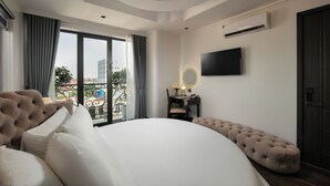 Une chambre dotée d’un grand lit, d’une coiffeuse avec un miroir, d’un téléviseur à écran plat et d’un appareil de climatisation.
