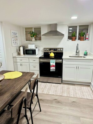 Enjoy cooking in this well-equipped kitchen with a central island, stainless steel range, and ample counter space.