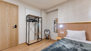 A bedroom with a wooden wardrobe, a bed with a white pillow, a small table, and a chair. - Comfortable Private Suite in Condesa area (18) (Mexico)