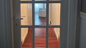 A hallway with wooden flooring and a bed in the background. - Liguria - Galleria Goito La Spezia (La Spezia)