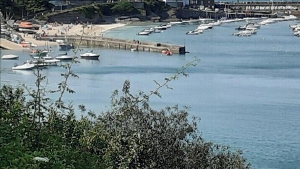 A coastal town with a pier extending into the sea, surrounded by buildings and boats. - Haven Caravan Sleeps 6 Pet Friendly (Newquay)
