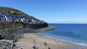 A coastal town with terraced houses along the cliffside, a sandy beach, and the sea. - Haven Caravan Sleeps 6 Pet Friendly (Newquay)