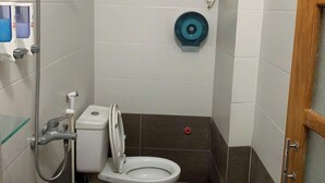 Un baño pequeño con inodoro, bidé y ducha.