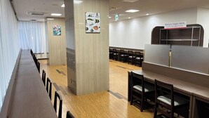 A long dining table with chairs, a return tray station, and a wall with marine life illustrations. - Hotel Alpha-One Kashiwazaki (Kashiwazaki)