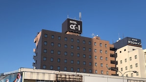A multi-story hotel with a sign reading "HOTEL α-1" and another sign in a different language. - Hotel Alpha-One Kashiwazaki (Kashiwazaki)