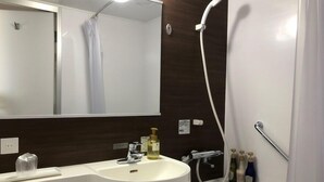 A bathroom with a white sink, a mirror, a shower, and toiletries. - Hotel Alpha-One Kashiwazaki (Kashiwazaki)
