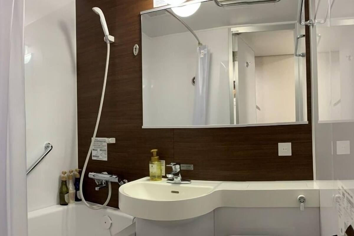 Ein modernes Badezimmer mit Waschbecken, Spiegel und Dusche.
