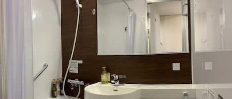 Un baño moderno con un lavamanos blanco, un espejo y una ducha.