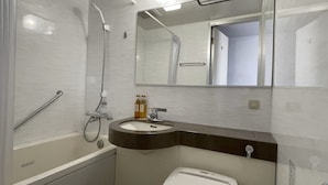 Egy modern fürőszoba, amelyben kád, mosdókagyló és WC található.