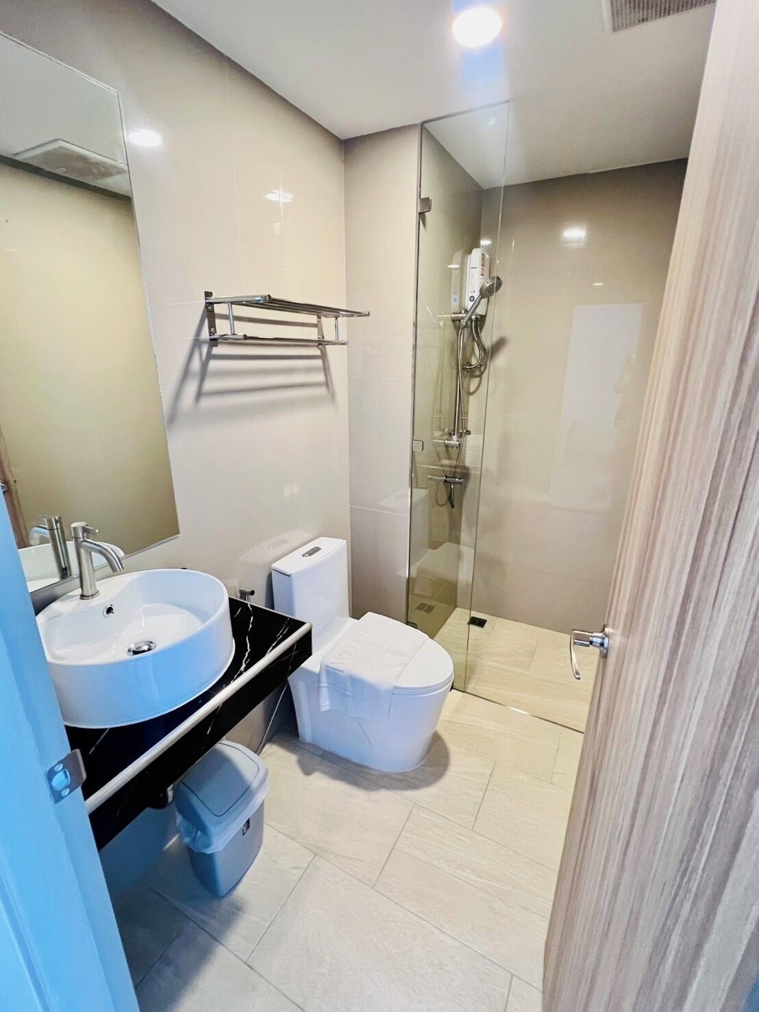 A modern bathroom with two sinks, a toilet, and a glass-enclosed shower.