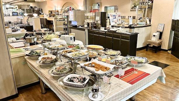 A buffet setup with various food stations and a wine glass on a table. - Hotel Alpha-One Mishima (Mishima)