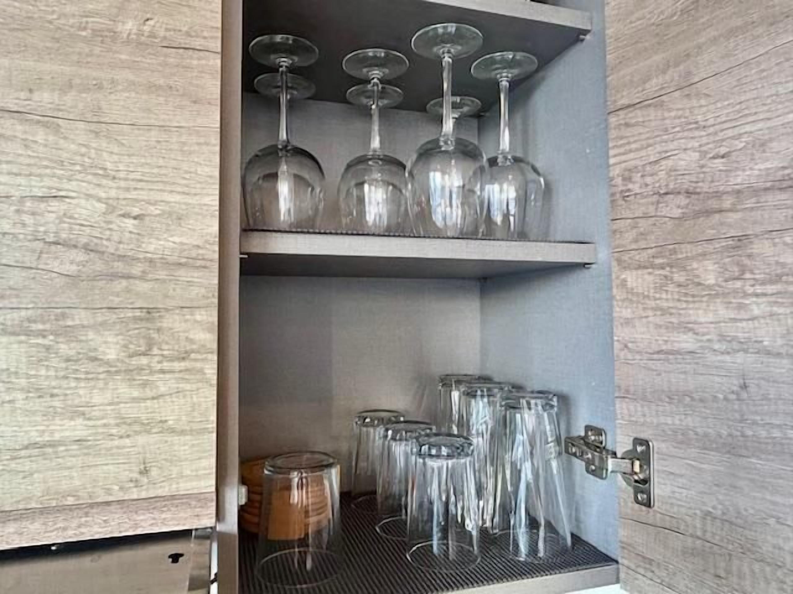 Un armario con copas de vino y vasos.