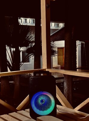 A room with a wooden table, a chair, and a colorful light fixture. - Bamboo Nest (Pollachi)
