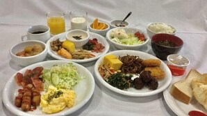Un bufé de desayuno con diferentes platos, bebidas y acompañamientos.