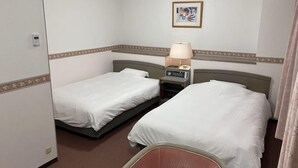 A hotel room with two single beds, a bedside table with a lamp, a small table with a phone, and a picture on the wall. - Hotel Alpha-One Sabae (Sabae)