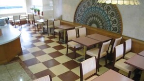 Un restaurante con piso a cuadros, mesas de madera y sillas acolchadas.