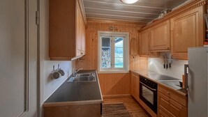A compact kitchen with wooden cabinets, a stainless steel sink, and a built-in oven. - Awesome home in Lillehammer with sauna (Lillehammer)