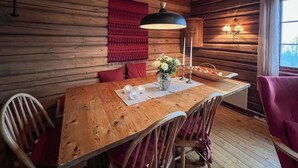 A wooden dining table with chairs, a vase with flowers, and a candle on a placemat. - Awesome home in Lillehammer with sauna (Lillehammer)