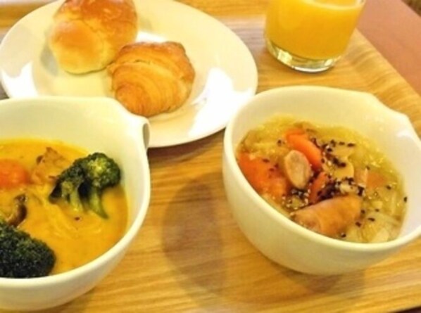 A tray with a croissant, a bowl of soup with vegetables, and a glass of orange juice. - Hotel Alpha-One Tsuruga-Bypass (Tsuruga)