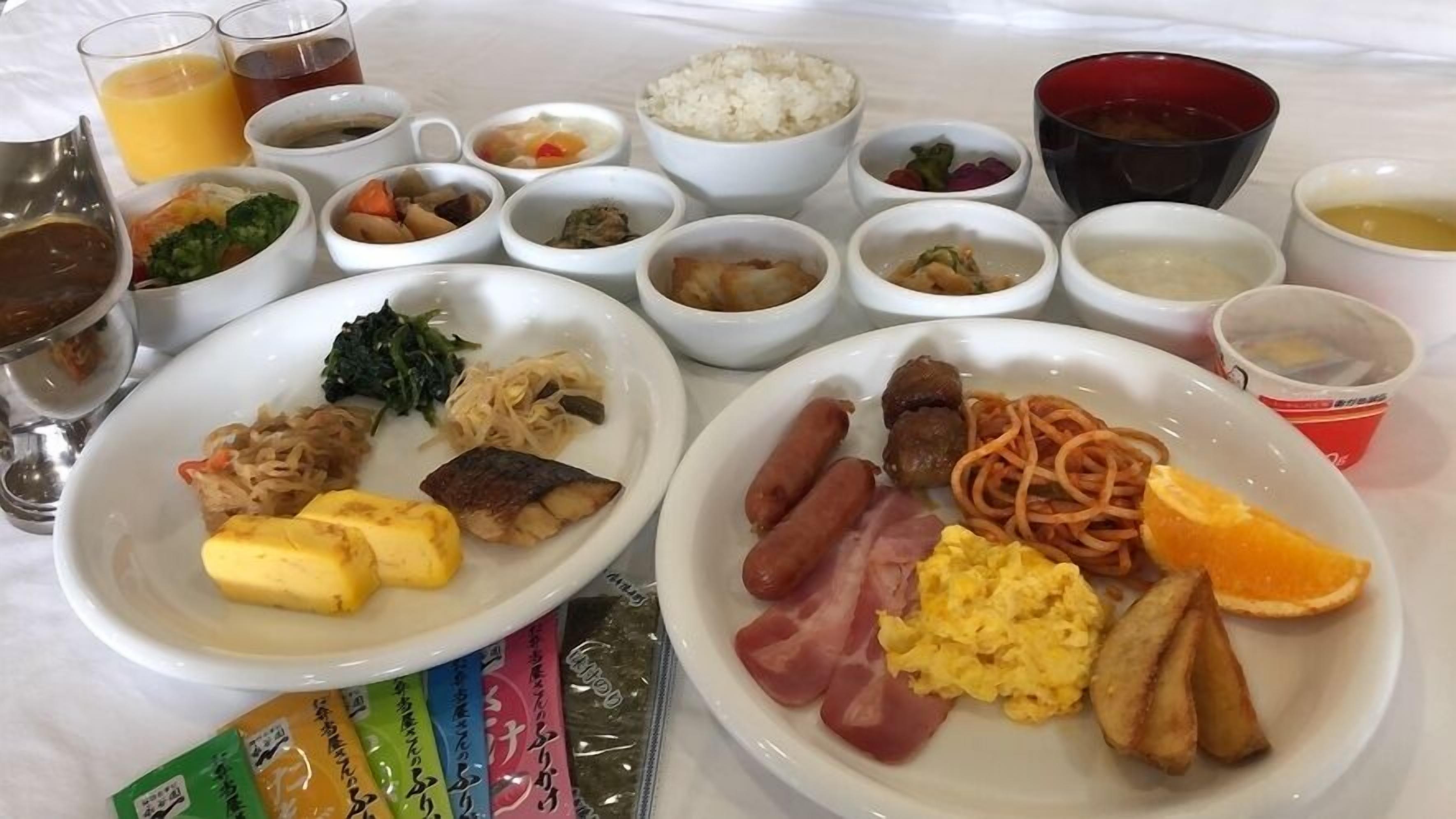 A table with various dishes including rice, vegetables, and meats, along with drinks and condiments.