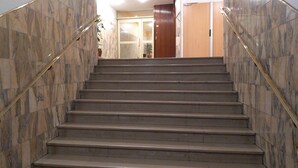 A staircase with marble walls and wooden doors at the top. - Sweet Home Panoramic Sacré Coeur  (Paris)