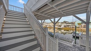 Una escalera conduce a un espacio cubierto con vistas a casas y una masa de agua.