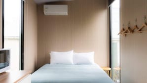 Une chambre d’hôtel moderne équipée d’un lit, d’une télévision et d’un panneau mural en bois.