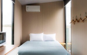 Een moderne hotelkamer met een bed, een televisie en een houten wandpaneel.