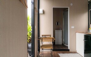 A compact kitchen with a wooden table and bench, a small refrigerator, and a sink. - Weka Pass Cottages 4 by Tiny Away (Waikari)