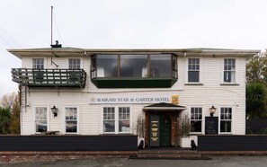 A two-story building with a sign reading "Waikari Star & Garter Hotel". - Weka Pass Cottages 4 by Tiny Away (Waikari)