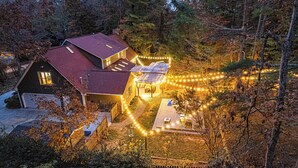 Ein Haus mit rotem Dach, einer überdachten Terrasse und Lichterketten.