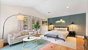 Ein modernes Schlafzimmer mit Bett, Sofa und einem großen Fenster.