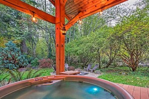 A hot tub under a wooden gazebo surrounded by lush greenery. - Summer Lodge Life! 5bd+4bath+HotTub+Sauna+EV (Ashford)