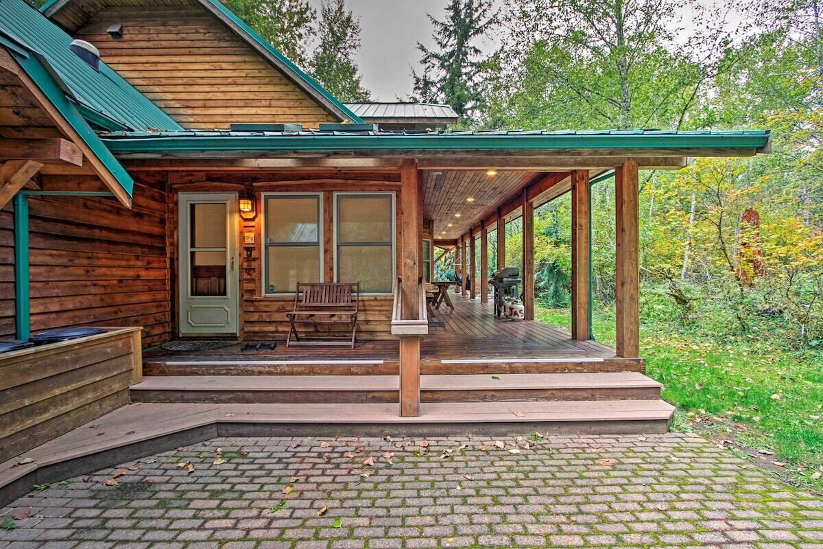 Une cabane en bois dotée d’un porche couvert, d’un banc et d’une porte avec un luminaire.