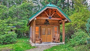A wooden cabin with a green roof, two wooden chairs, and a brick pathway leading to it. - Summer Lodge Life! 5bd+4bath+HotTub+Sauna+EV (Ashford)