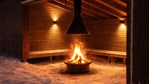 Ein Holzhaus mit Feuerstelle inmitten von Schnee.