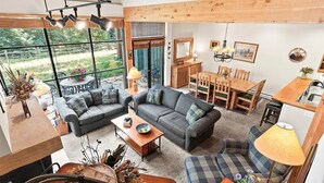 A spacious living area with a large window, a dining table, and a cozy seating arrangement. - Spacious 2-bedroom 2.5 Bath Townhome Walking Distance to World Class Skiing!  (Keystone)