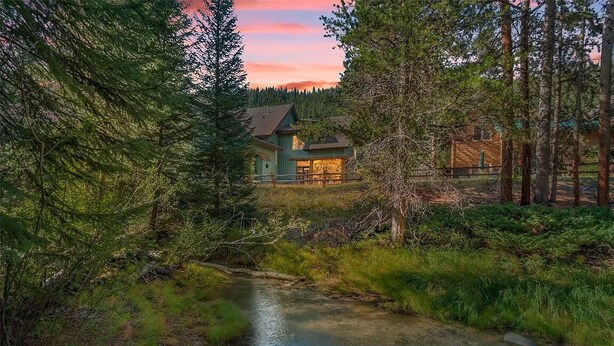 A house with a visible front porch and a small stream in front. - Spacious 2-bedroom 2.5 Bath Townhome Walking Distance to World Class Skiing!  (Keystone)