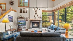 A cozy living room with a fireplace, large windows, and a staircase. - Spacious 2-bedroom 2.5 Bath Townhome Walking Distance to World Class Skiing!  (Keystone)