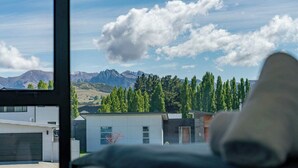 Um edifício moderno com vista para montanhas e árvores.